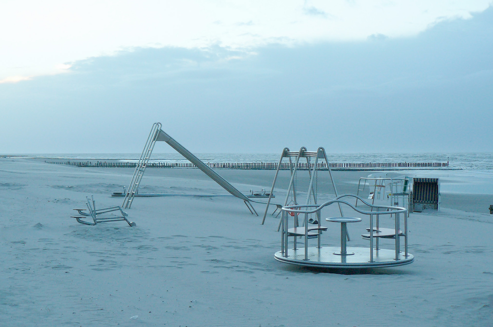 Ein verlassener Spielplatz abends direkt im Sandstrand, es ist noch hell aber man sieh, es ist kalt.